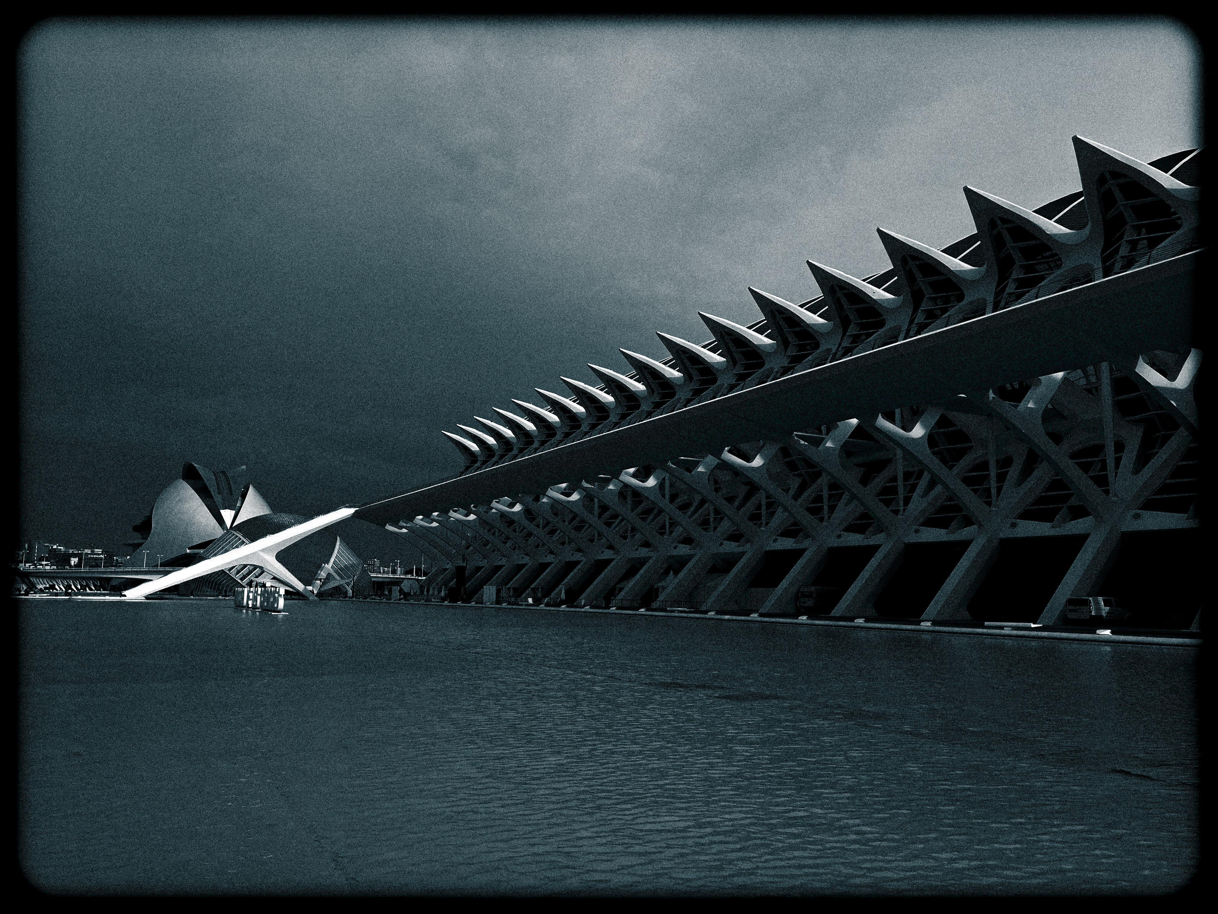 a black and white photo of a building under a cloudy sky